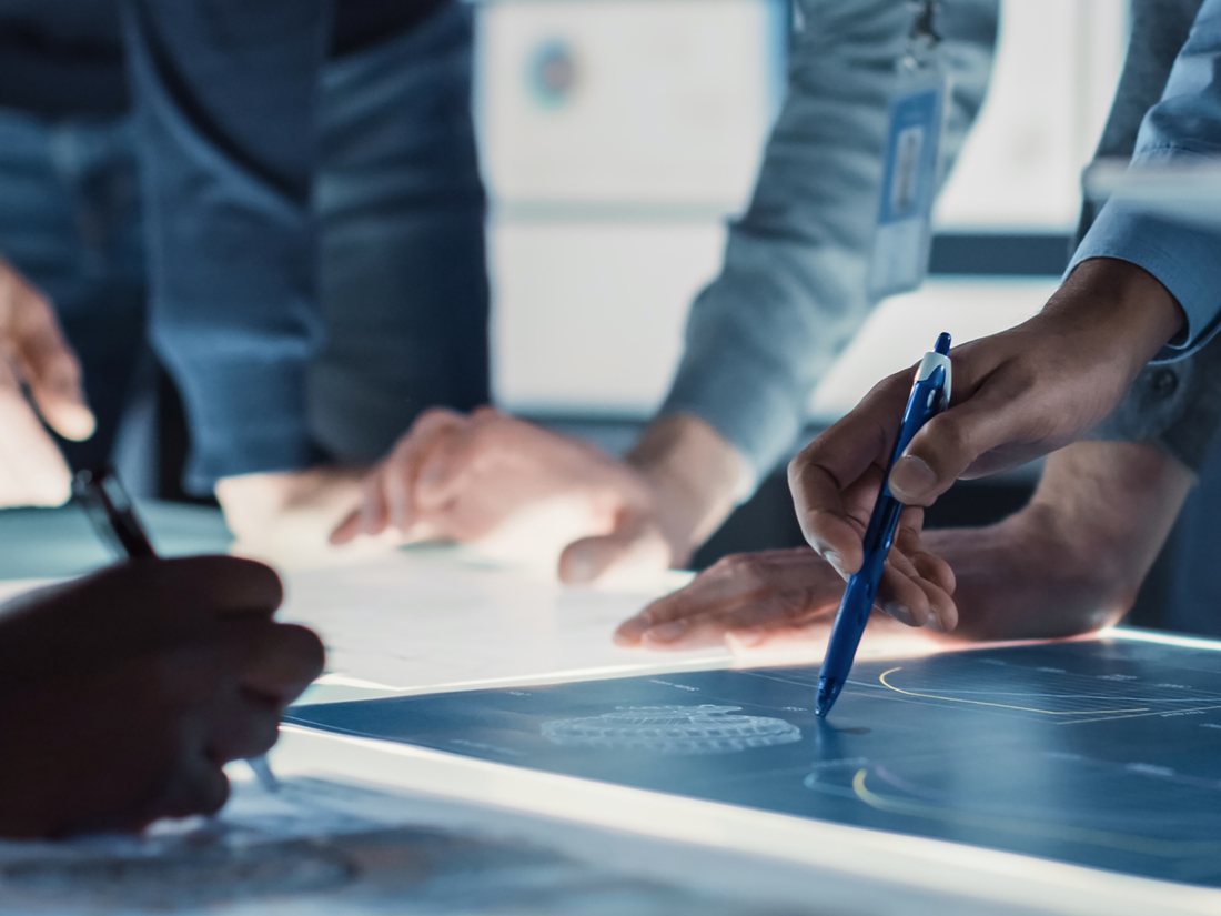 A hiring team working through plans together at a lit table